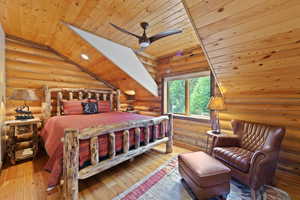 Wood-paneled bedroom featuring a sloped ceiling with recessed lighting and a ceiling fan