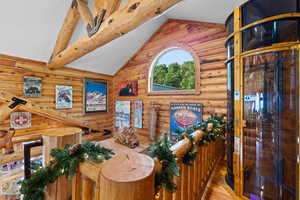 Log construction throughout, featuring exposed timber beams and an arched window