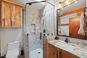 Glass-enclosed shower featuring mosaic tile and a built-in niche