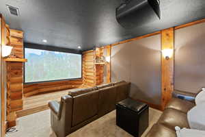 Dedicated theater room featuring a large projection screen and projector