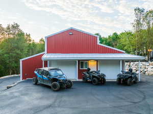 Red metal barn-style structure with white trim and a covered porch