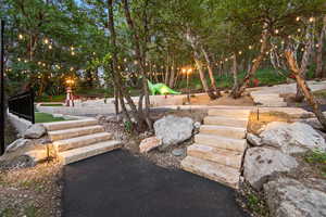 Terraced backyard featuring a putting green with decorative lighthouse and dinosaur figures