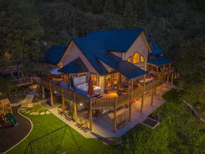 Multi-level property with a metal roof and extensive wood decking, featuring a built-in hot tub