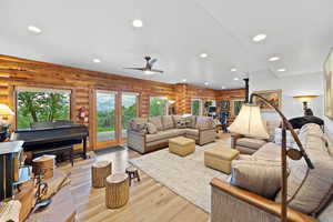 Spacious living area featuring extensive log-wall finishes and light wood-finish flooring