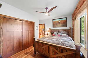 Wood-finish flooring with panel closet doors and a rustic log wall