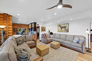 Spacious living area featuring light wood-finish flooring and recessed lighting