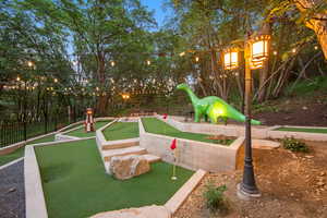 Custom mini-golf course featuring artificial turf, concrete retaining walls, and string lighting