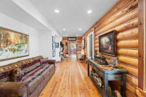 Hardwood flooring extending through a hallway with recessed lighting