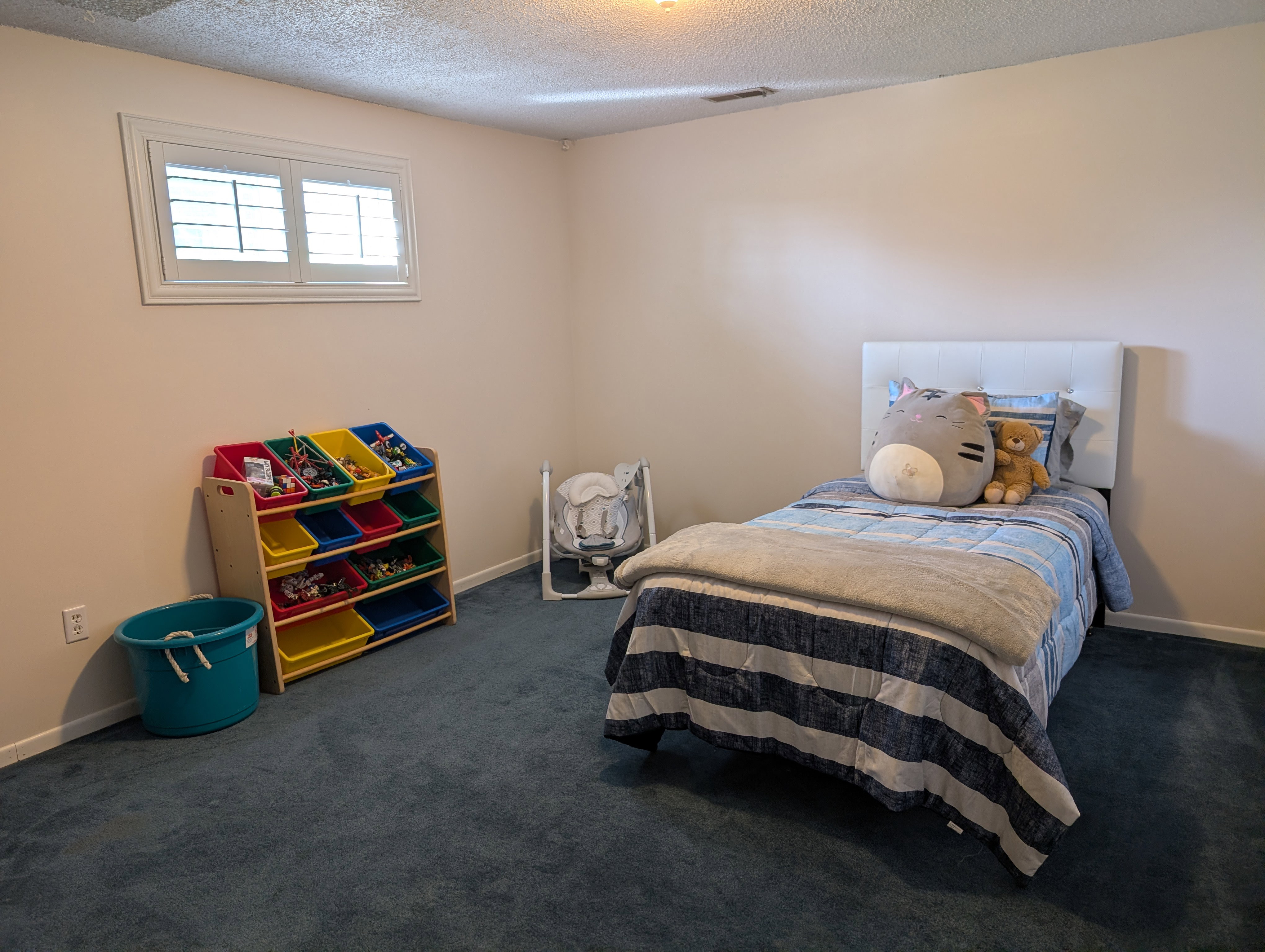 Bedroom with neutral wall paint with baseboard trim and blue carpeting