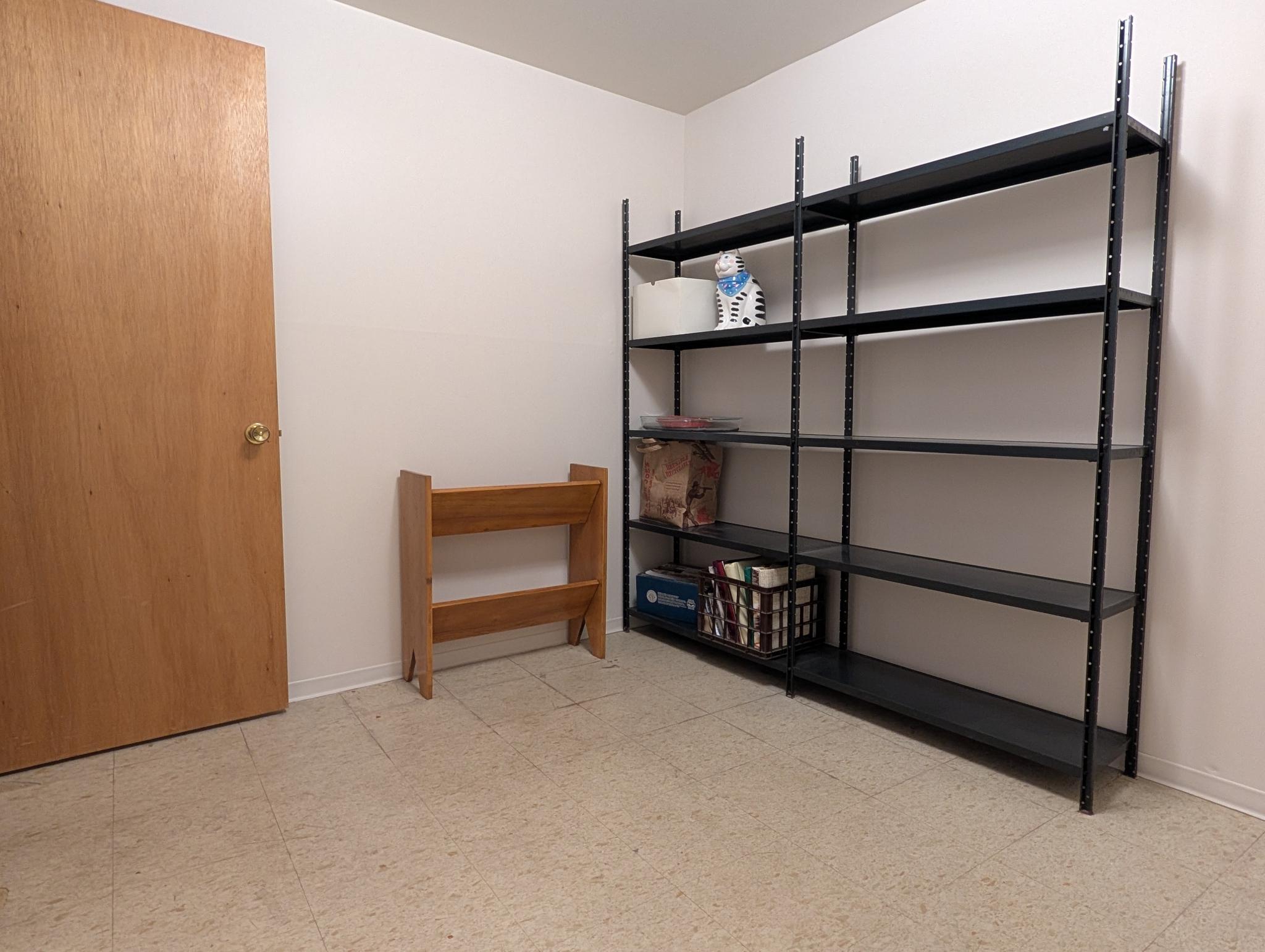 Utility/craft room featuring light-toned flooring, a light wood-finish door.