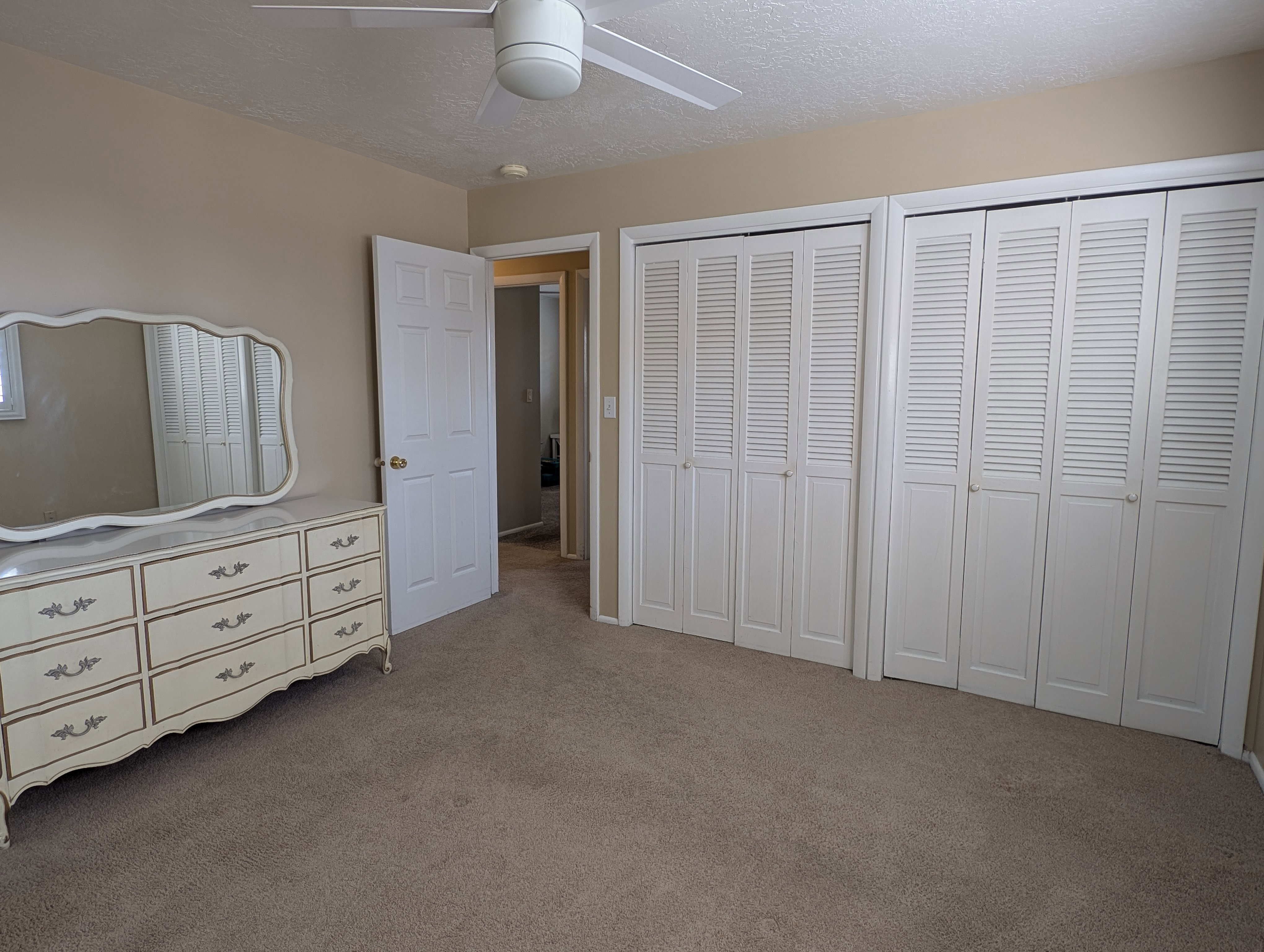 Master bedroom with wall-to-wall carpeting and neutral wall tones