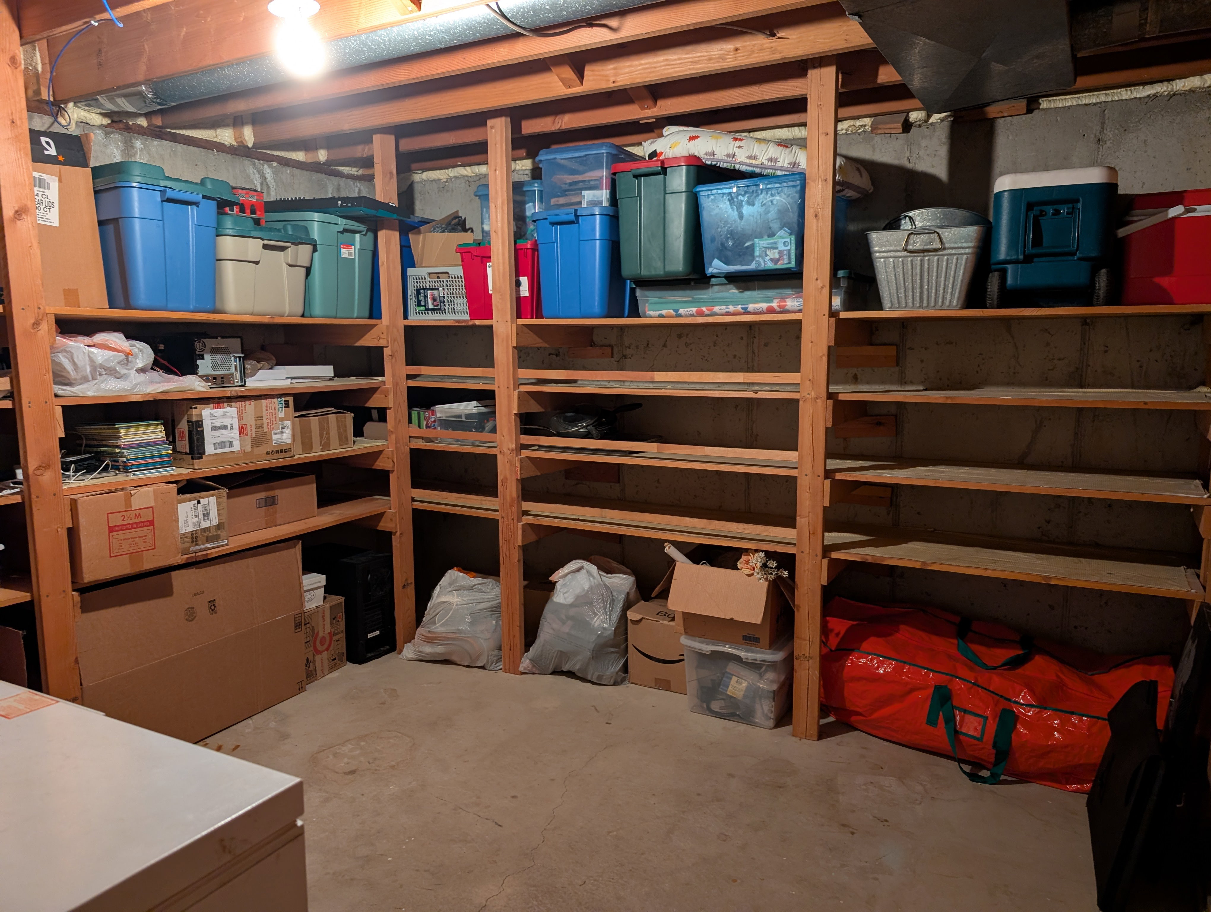 Unfinished basement area featuring extensive built-in wooden shelving for ample storage.