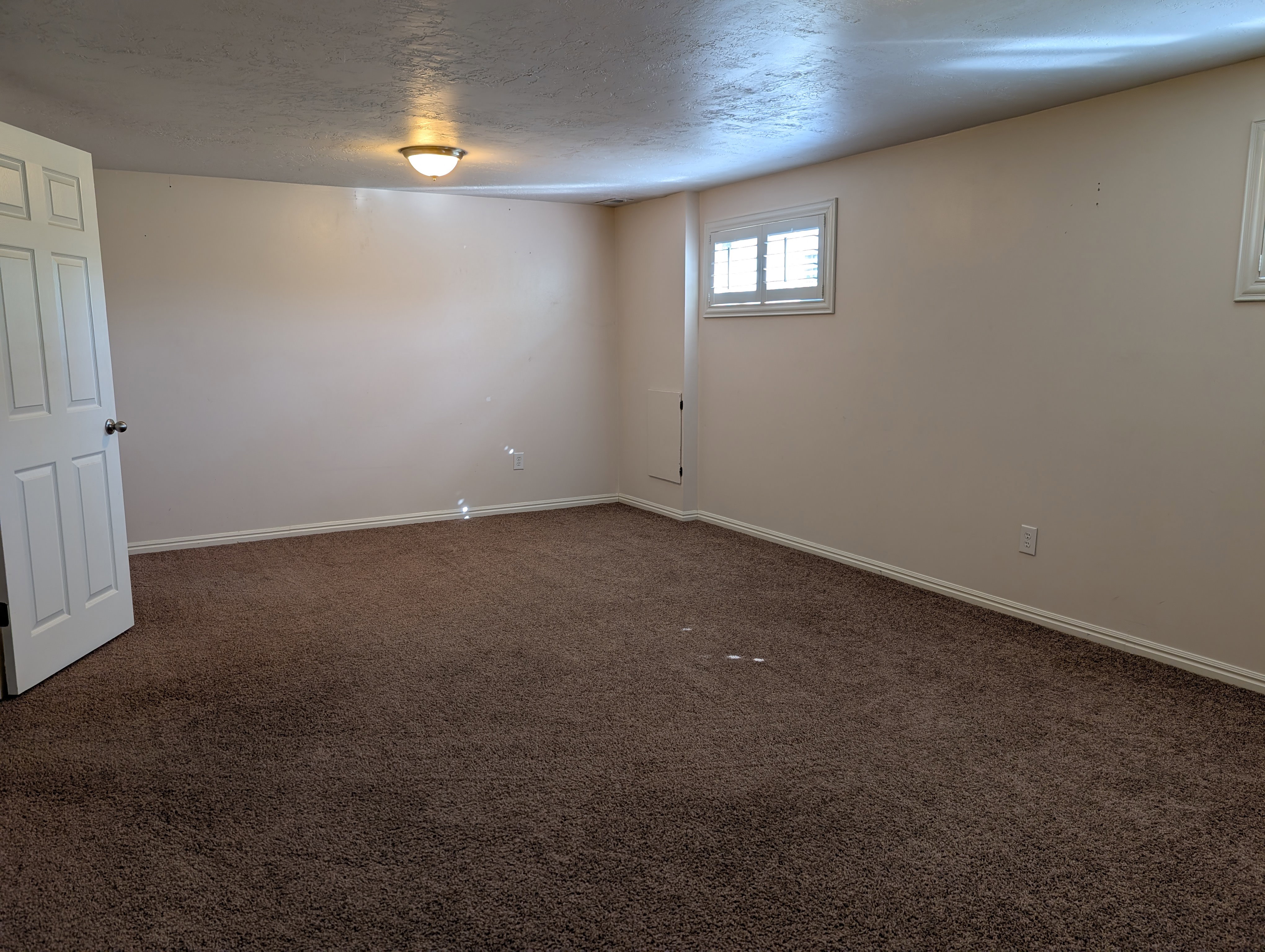 Large multipurpose room with neutral wall tones and white baseboards