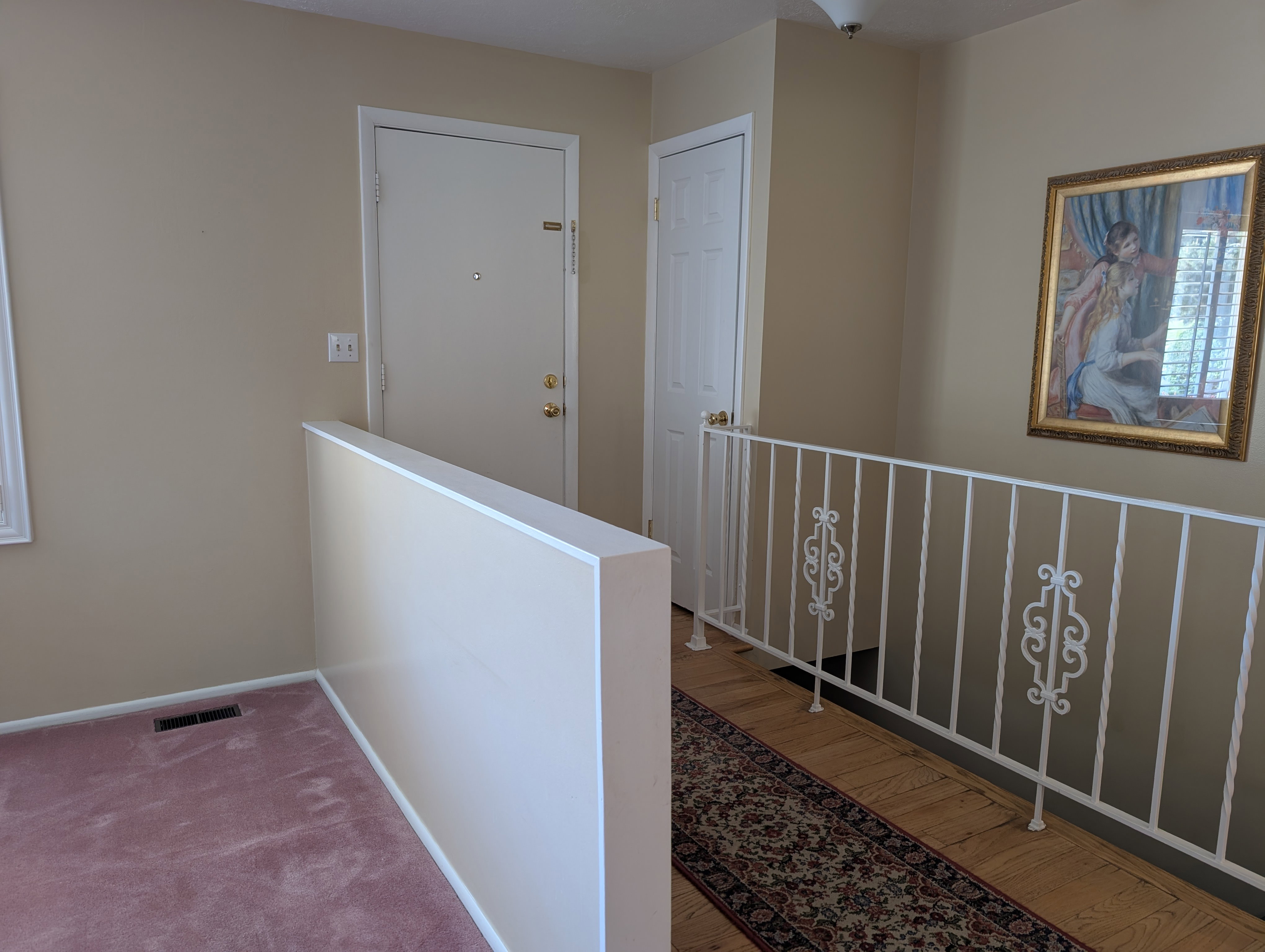 Front door with half-wall separating the living room from the entry