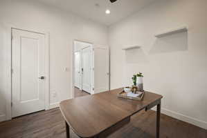 Home office with dark wood-type flooring and recessed lighting