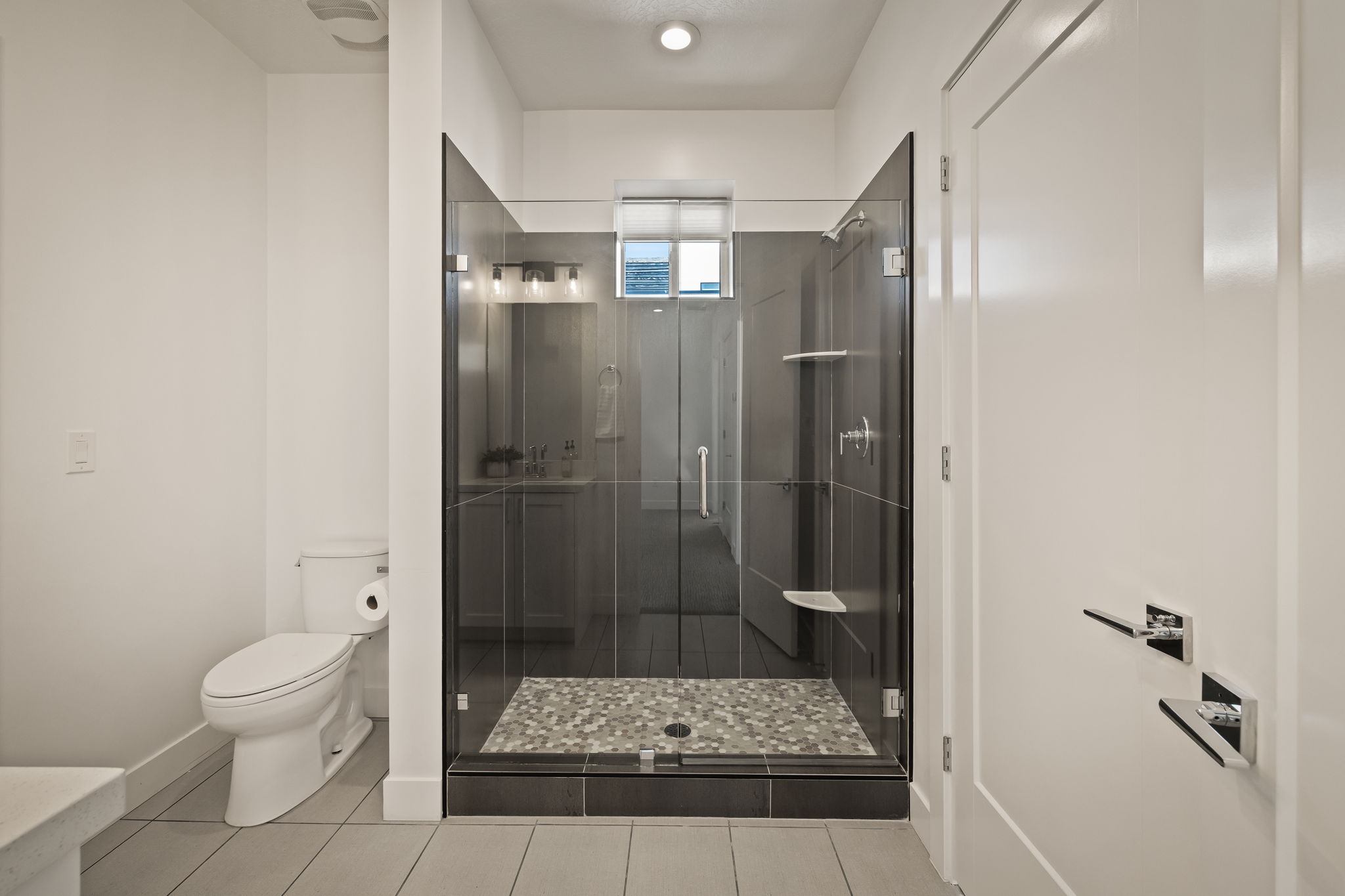 Full bath with a shower stall and light tile patterned floors