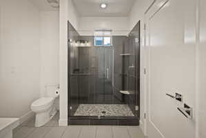 Full bath with a shower stall and light tile patterned floors