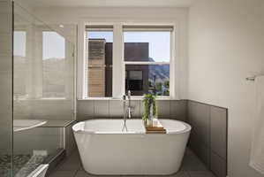 Full bathroom with a stall shower, healthy amount of natural light, a freestanding tub, and light tile patterned floors