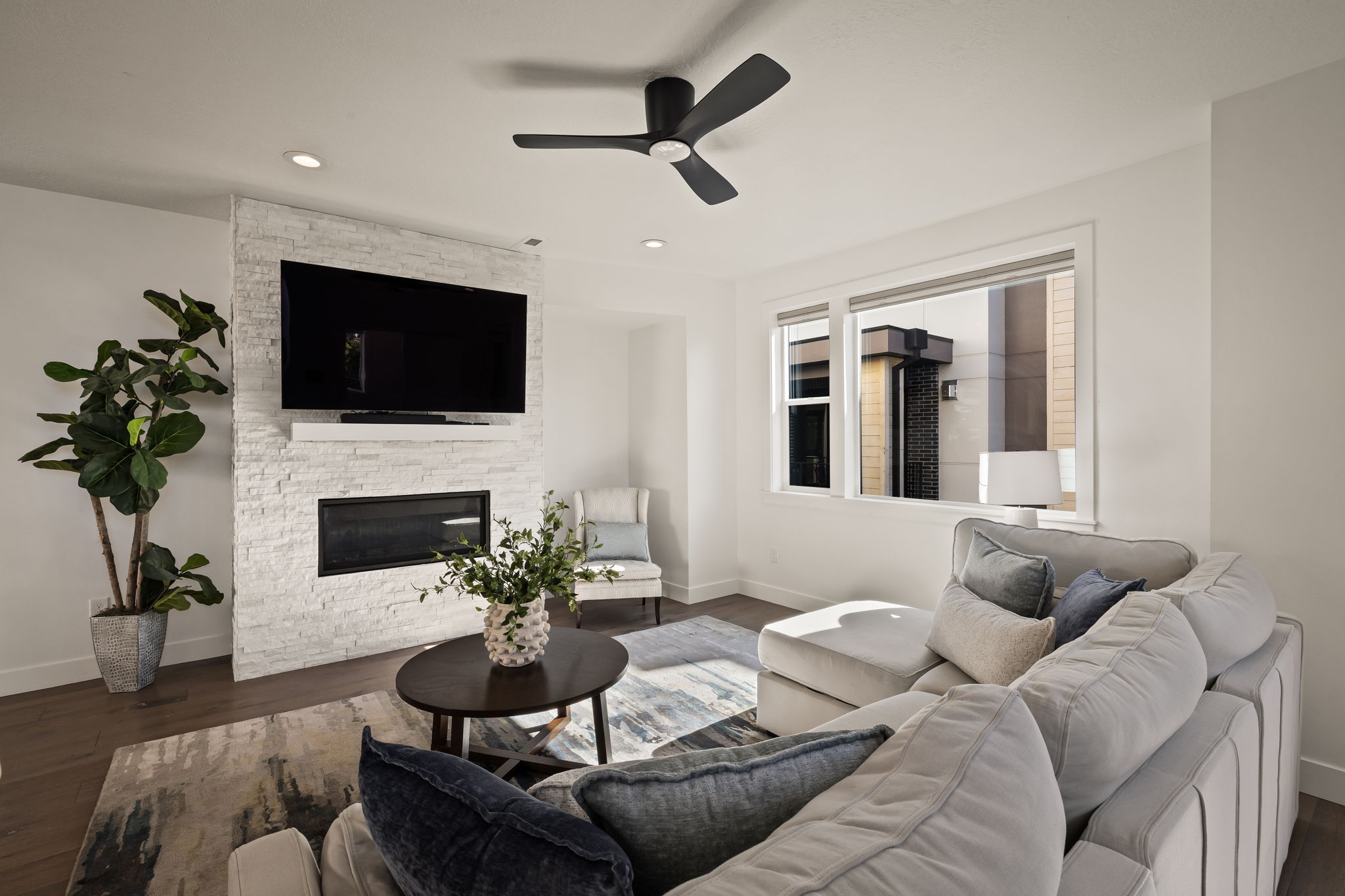 Living room with a ceiling fan, wood finished floors, a fireplace, and recessed lighting