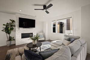 Living room with a ceiling fan, wood finished floors, a fireplace, and recessed lighting
