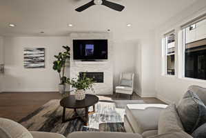 Living area with ceiling fan, a fireplace, wood finished floors, and recessed lighting