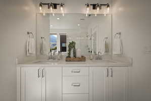 Bathroom featuring a shower stall, double vanity, and recessed lighting