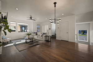 Living area with dark wood finished floors, ceiling fan, and suspended lighting