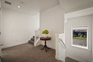Staircase with carpet flooring and recessed lighting