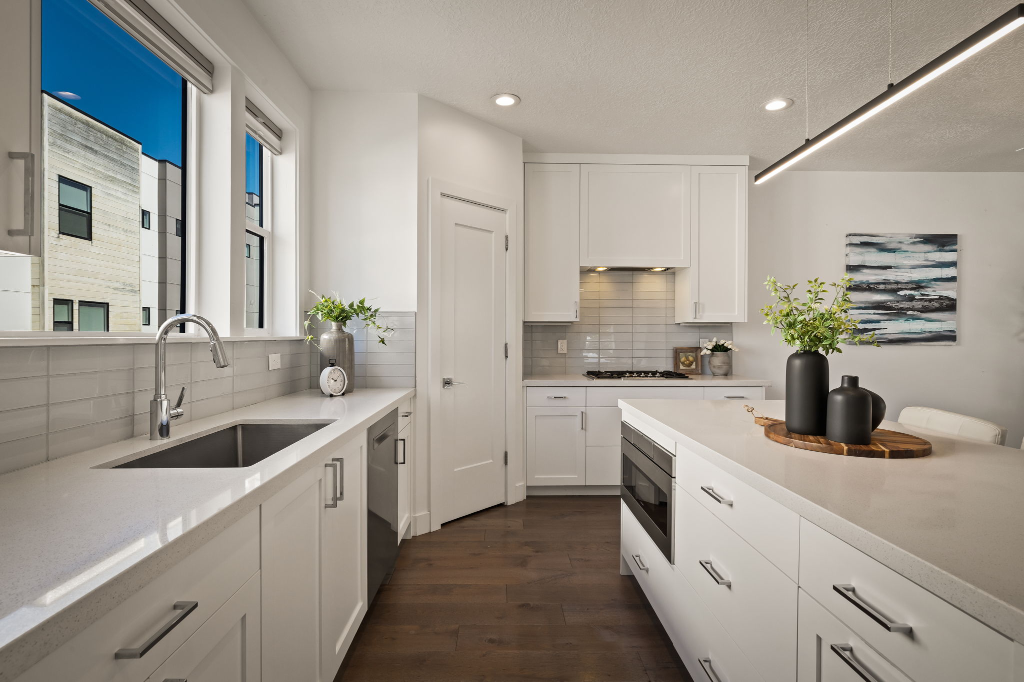 Kitchen with white cabinets, dark wood finished floors, recessed lighting, decorative backsplash, and stainless steel appliances