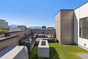 View of grassy yard featuring a patio area, outdoor lounge area, and a mountain view