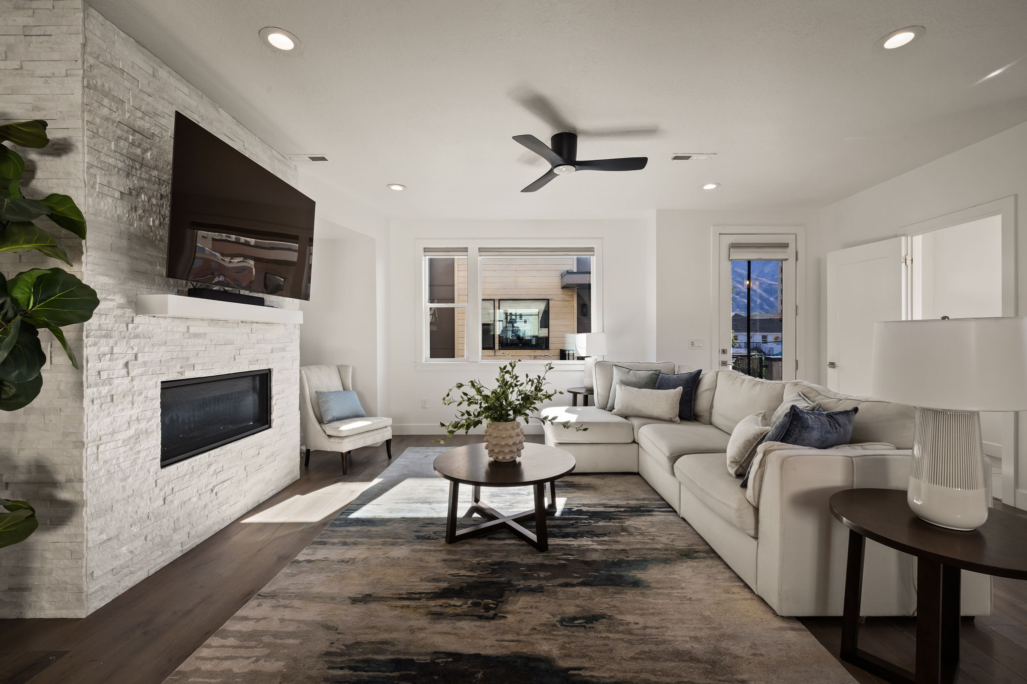 Living room featuring a fireplace, a ceiling fan, dark wood-type flooring, and recessed lighting