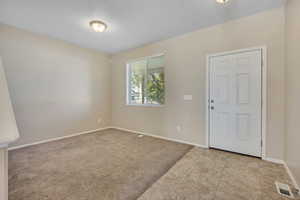 Entry area featuring a four-panel door, neutral wall color, and a window with blinds