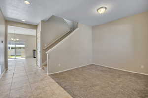 Entryway with tile flooring opening to a carpeted living area