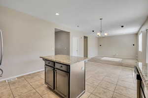 Kitchen island with granite-style countertop and dark cabinetry