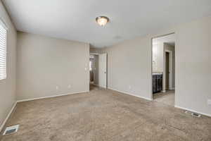Carpeted room with neutral wall tones and white baseboards