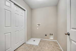 Laundry area featuring tile flooring, white paneled bifold doors, and a utility sink basin