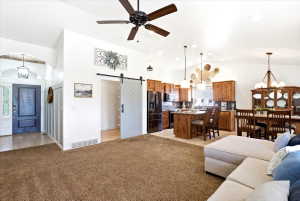 Open-concept living space featuring vaulted ceilings, a ceiling fan, and recessed lighting