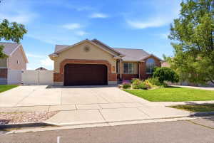 Ranch-style residence featuring a brick and stucco facade, a two-car garage with a dark wood-finish door, and a concrete driveway