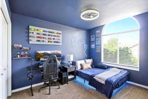 Main floor bedroom 3 - Room featuring a large arched window with blinds, a built-in closet with white bifold doors, neutral-toned carpet, and a modern ceiling fan with integrated lighting