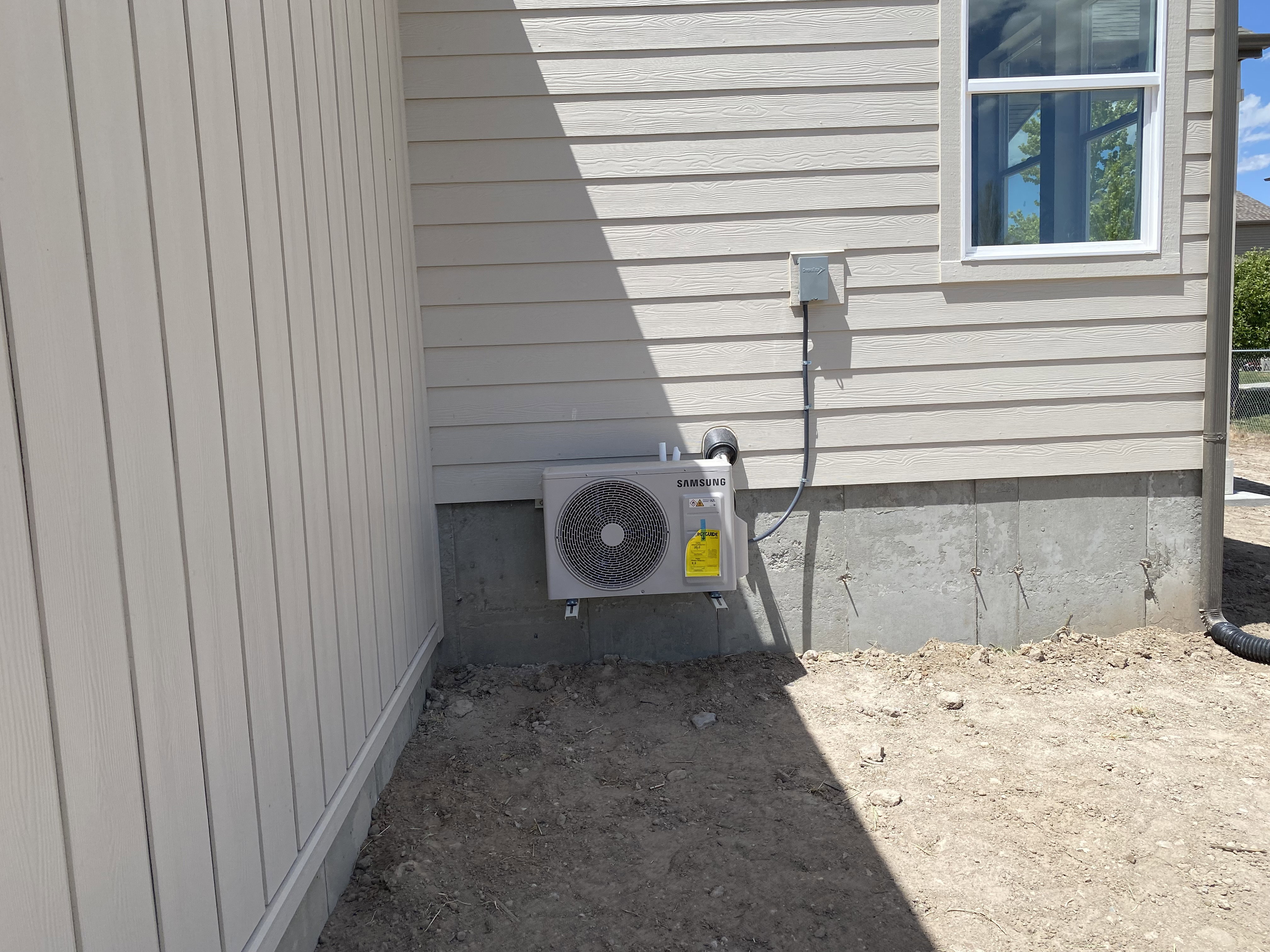New exterior air conditioning unit installed on a concrete foundation
