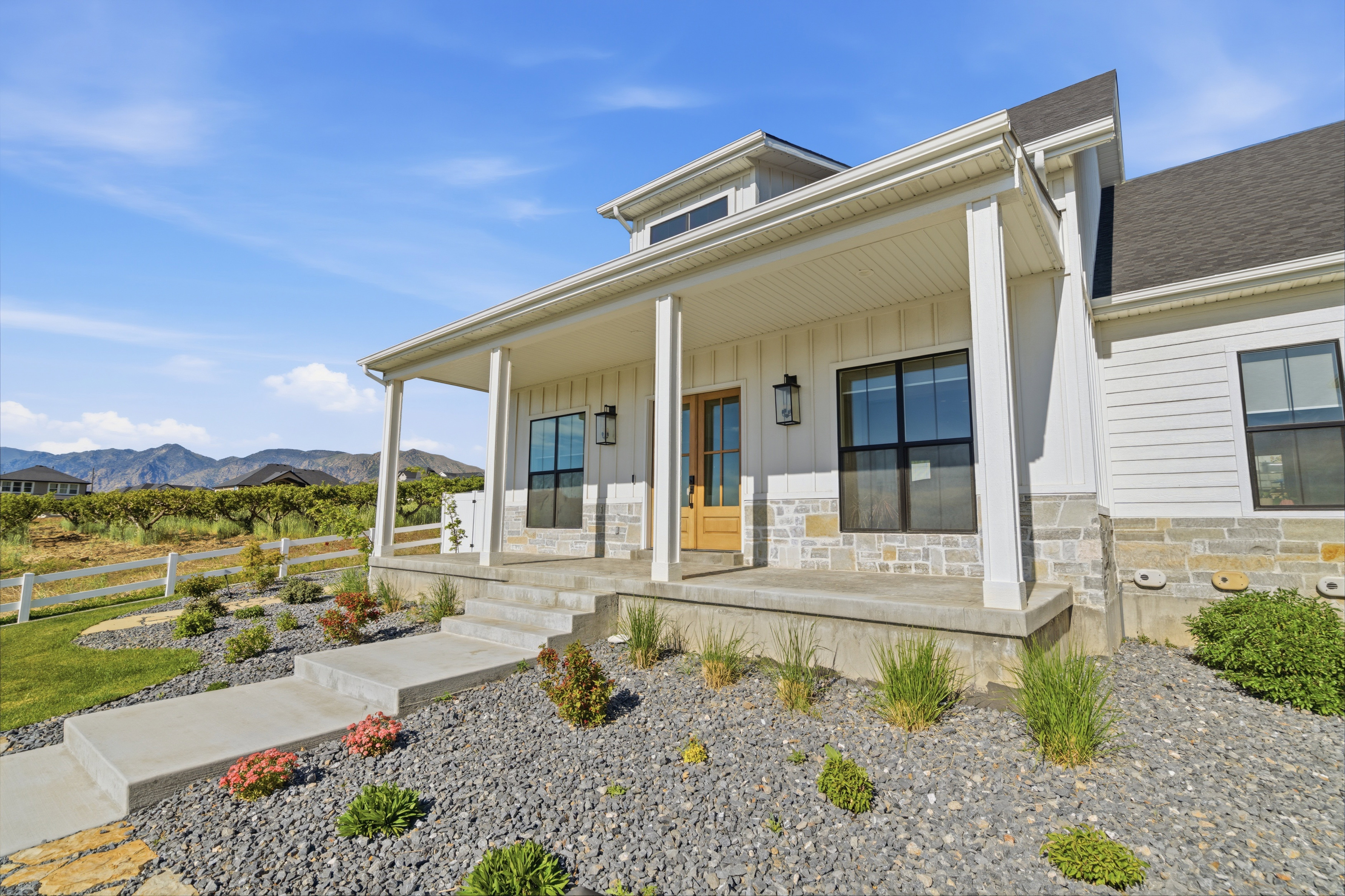Inviting covered porch featuring substantial columns and stone detailing