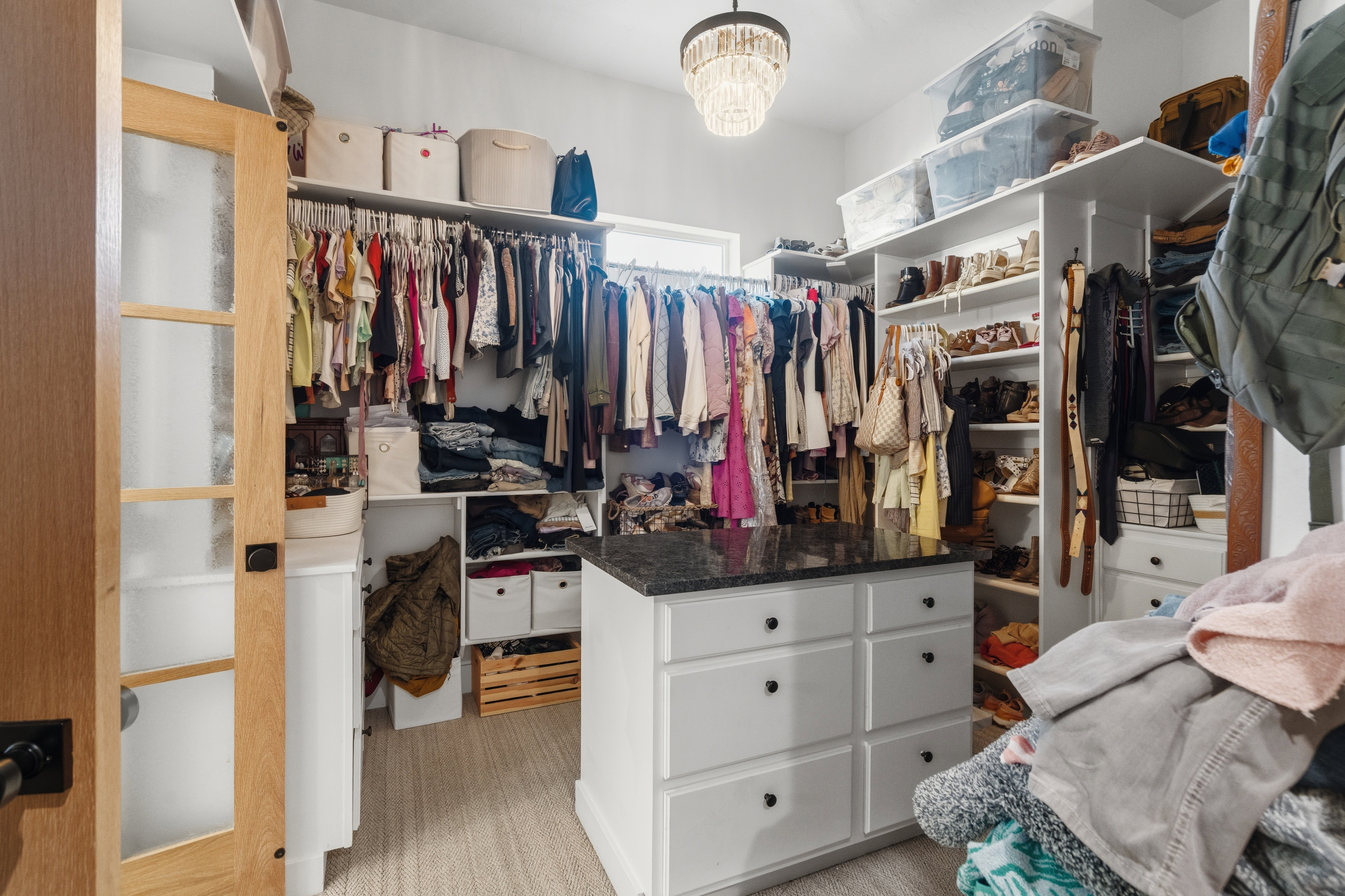 Spacious walk-in closet featuring an organizational system with built-in shelving and hanging rods