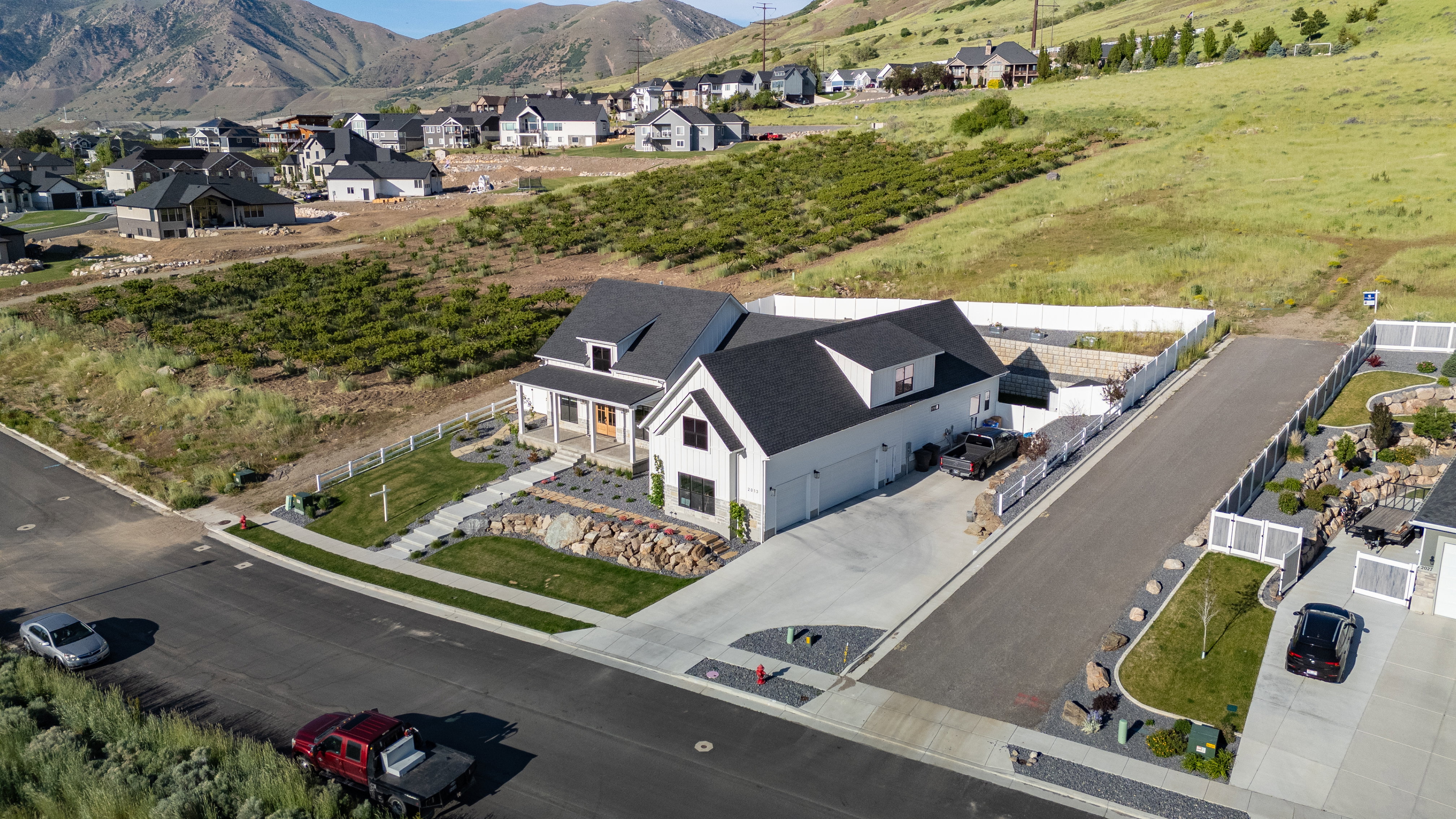 Modern farmhouse exterior with a prominent front porch and a multi-car driveway