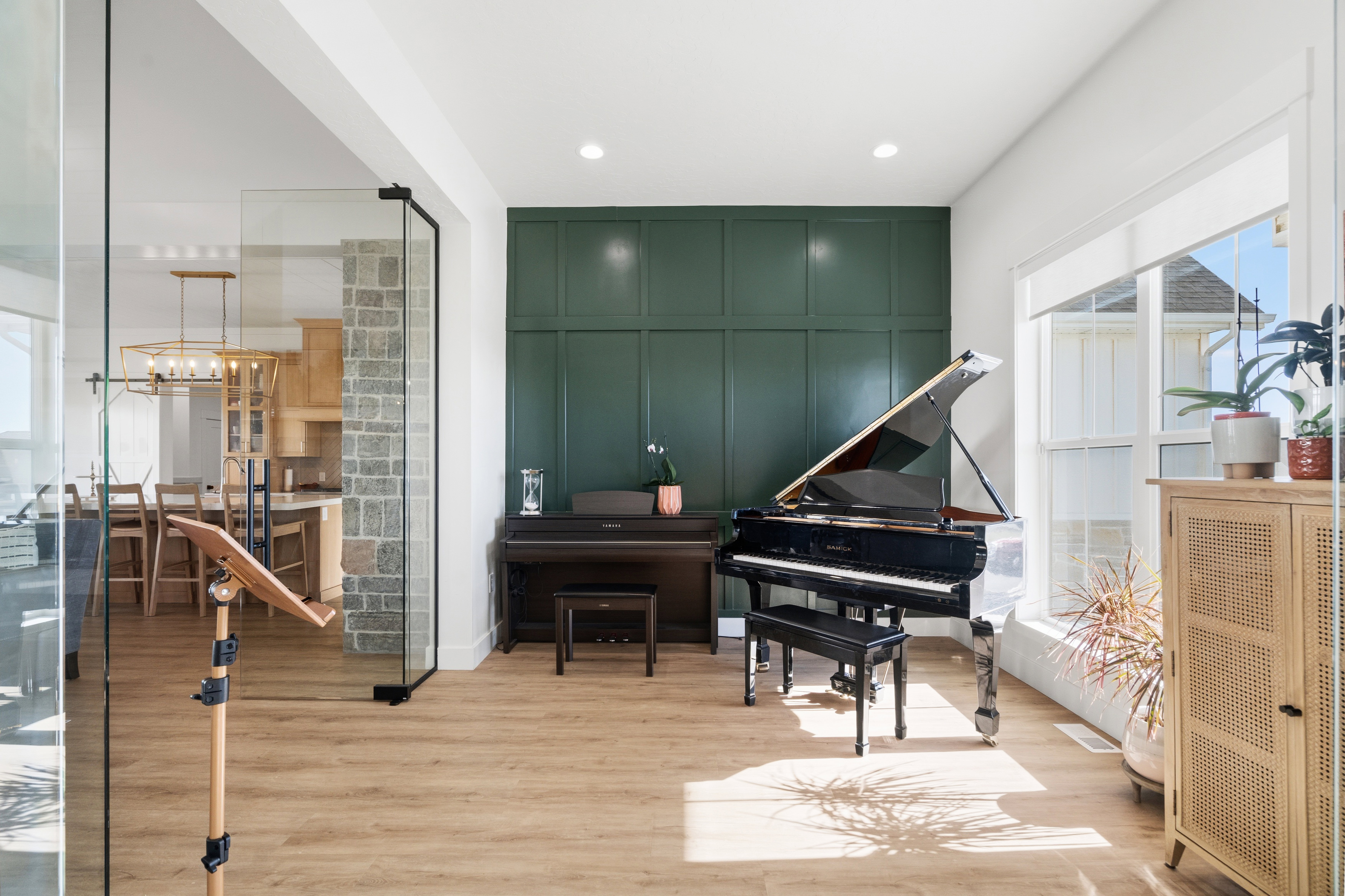 Spacious interior room featuring wood-finish flooring, a detailed panel accent wall, and recessed lighting