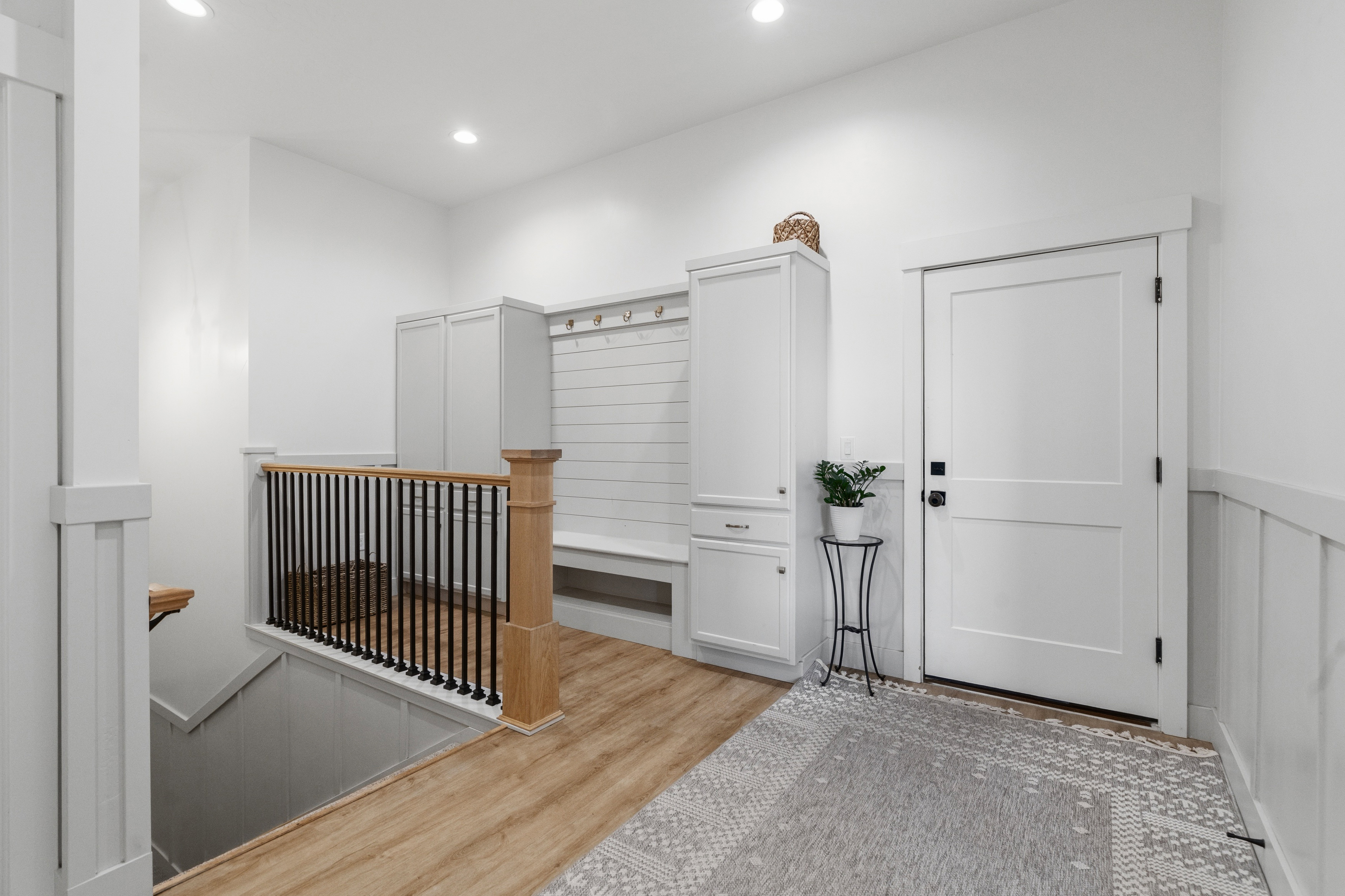 Entryway featuring wood-finish flooring, recessed lighting, and a built-in mudroom bench with storage cabinetry and coat hooks