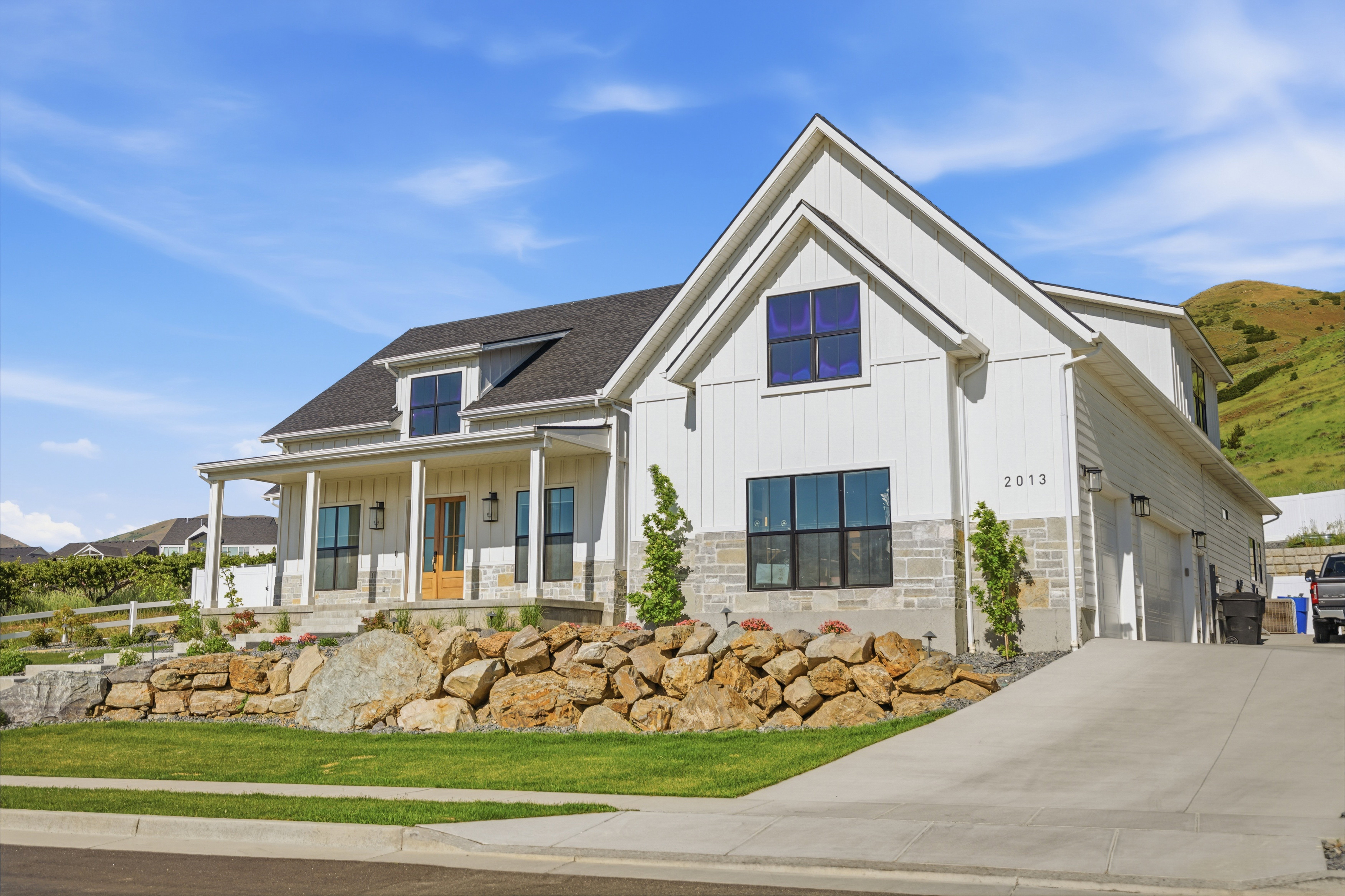 Modern farmhouse exterior with a covered front porch, board and batten siding, and stone accents