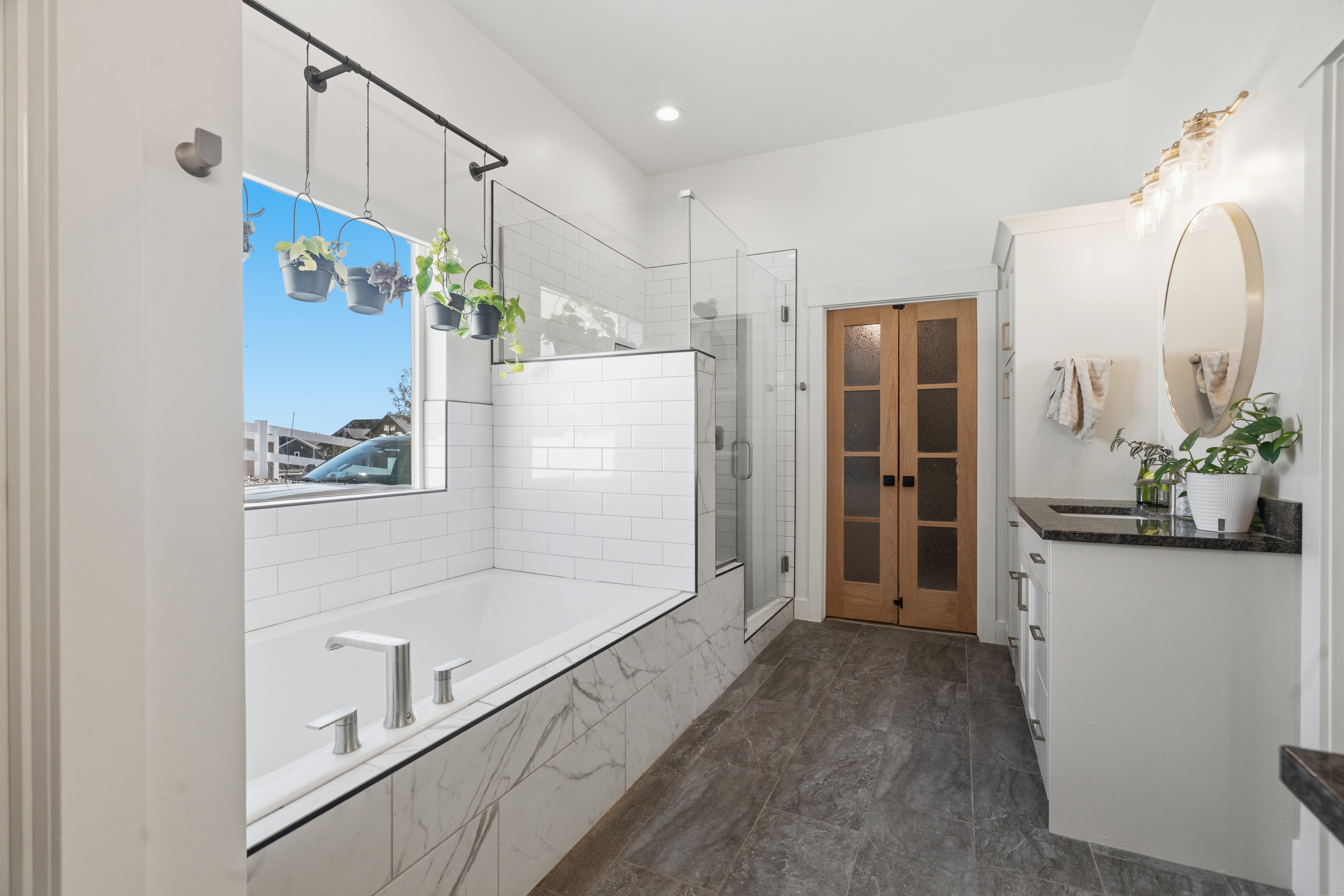 Sleek bathroom featuring a built-in tub with marble-look paneling and subway tile surround