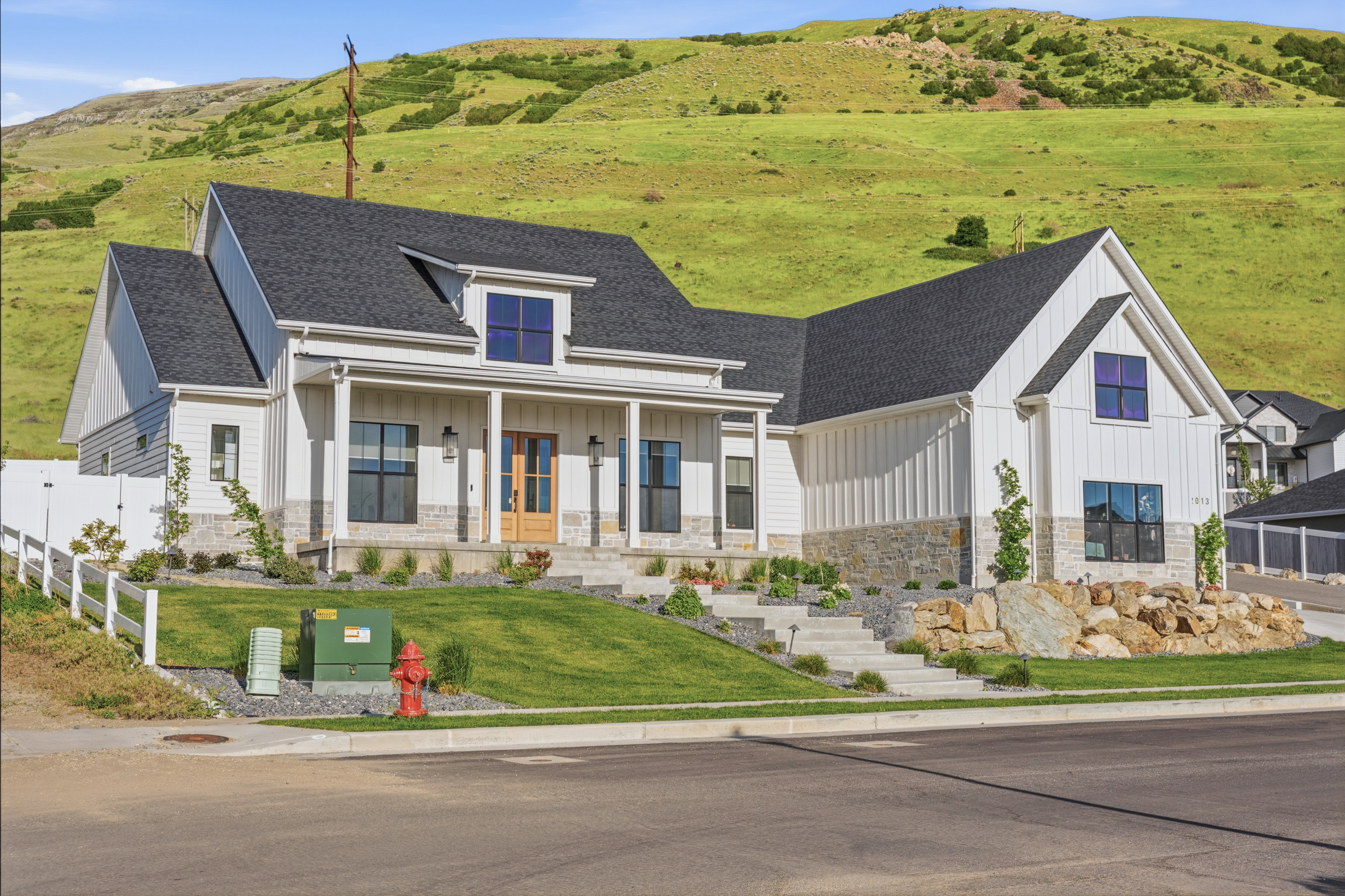 Modern farmhouse exterior with white board and batten siding and stone accents