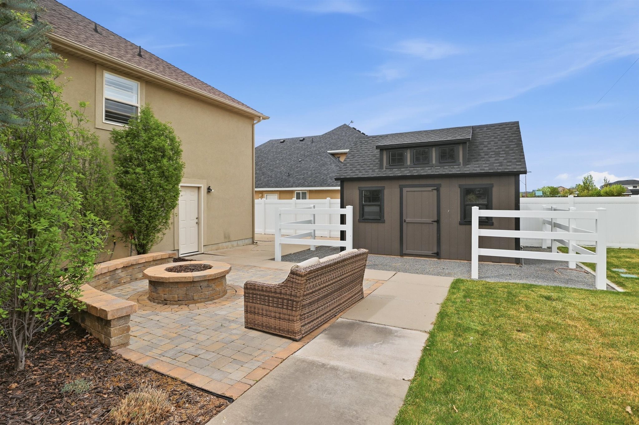 Outdoor patio featuring a stone fire pit, paver flooring, and a built-in seating wall