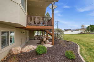 Two-story exterior featuring a private upper deck with wood railing and a covered lower patio